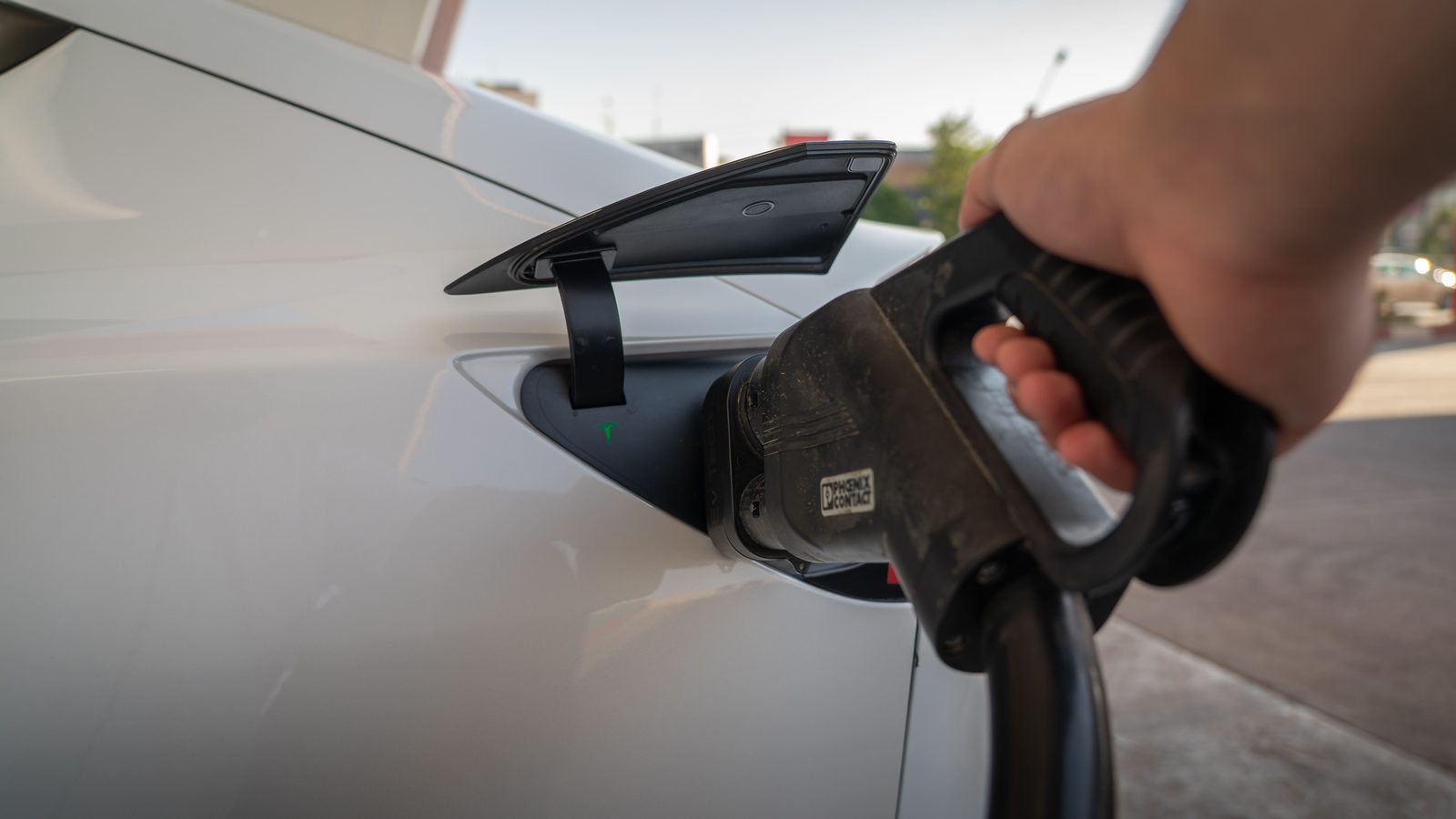 Electric luxury sedan charging outside a hotel